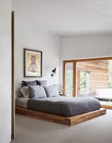 The master bedroom in this prefab passive house in the Catskills looks out onto a private, cantilevered deck. "This house for me is about contemplation," says homeowner Adrian. "You come here from the city and the place is saying, ‘Hi, meet yourself again.’" A low platform bed with stacked pillows instead of a headboard helps maintain that casual feel.