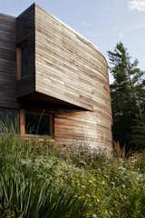 The cedar-wrapped house, designed by BriggsKnowles A+D, is gently curved at the center.