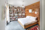 More bookshelves span a the wall in the bedroom. A cedar, walk-in closet is located behind a hidden door.