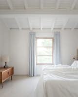 Exposed beams and rafters crown the guest bedroom.