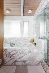 An oversized soaking tub in the bathroom is swathed in Calacatta marble.