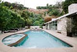 A large swimming pool awaits in the backyard, which is tucked into the hillside.