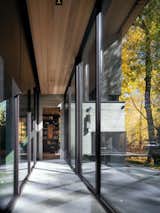 Dual-sided floor-to-ceiling glazing in the central interior walkway lends the sense that one is walking through the natural landscape, even inside the home.