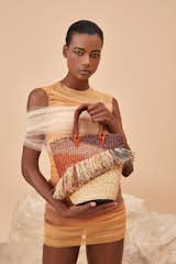 The Tia Ruffle bucket bag by AAKS is crafted from woven raffia in Ghana.