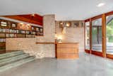 Concrete steps lead down to a wet bar near the living room. Glass doors lead out to the patio.