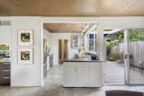 An opposite view from the dining area looks into the kitchen. A small peninsula connects the two spaces while a sliding glass door opens onto a side patio.