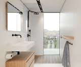 Even the bathroom grants views. Sleek wood elements complement the white-and-black fixtures and details.&nbsp;&nbsp;