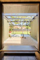 Floor-to-ceiling windows in the entryway provide views of the centrally placed Japanese Maple.