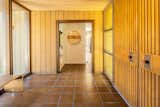 In the entryway, patterned amber-colored glass flanks both sides of the double walnut door.   Photo 8 of 16 in A Restored Post-and-Beam by a Richard Neutra Protégé Lists for $700K