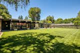 A view from the grassy backyard shows the patio stretching across the rear facade.  Photo 14 of 16 in A Restored Post-and-Beam by a Richard Neutra Protégé Lists for $700K