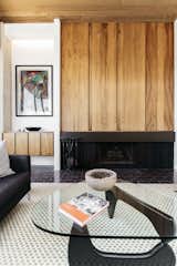 Lightly colored rough stucco walls contrast with a Brazilian rosewood above the fireplace. Original glazed brick pavers cover the floors.&nbsp;