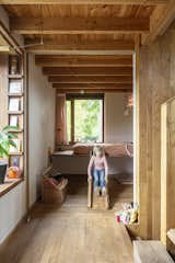 Kids Room, Bedroom Room Type, Bed, Pre-Teen Age, Shelves, Medium Hardwood Floor, and Neutral Gender Another of the children's bedrooms.  Photos from An Architect Couple Handcraft a Rustic Haven at the Edge of a Belgian Forest