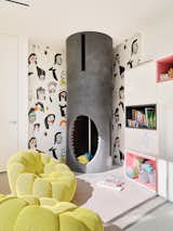 The playroom is outfitted with Bubble armchairs by Sacha Lakic from Roche Bobois and a custom fire pole that descends from the floor above. The wallpaper is FP502001 Shaman from Pierre Frey.