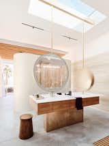 Circular mirrors by Dennis Luedeman join a custom walnut vanity with a counter and integrated sink by Corian. “The house is relentlessly linear, but we were able to add these more playful shapes,” Fougeron says. The faucets are V1/150 by Vola.