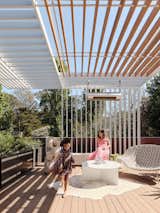 Trellises made of painted aluminum and Alaskan cedar shade a deck off the master bedroom. The Shito chaise longue is from Paola Lenti, the Cluster coffee table by Christian Woo, and the sculpture by Ryosuke Yazaki from The Future Perfect.