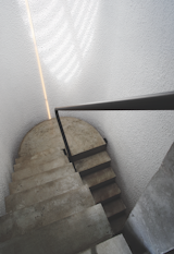 In the two-story stairwell, steps seem to float in space, thanks to a circular skylight that illuminates the walls. A continuous steel handrail connects the floors.