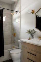 A view of another bathroom with zellige tiles and satin brass hardware.