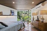 A look at one of two bedrooms on the upper level. The triangular-shaped space features a large wall of glass at one end and original wood-clad ceilings.  Photo 9 of 15 in A John Lautner Post-and-Beam Hits the Market for the First Time Ever