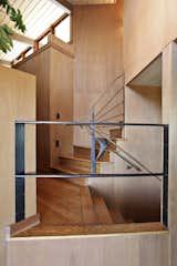 Steel railings define a staircase leading up to the second floor loft and bedrooms.