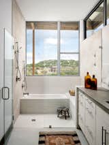 Every room in the house has access to natural light. The bathroom cabinets are standard mid-grade factory-built cabinets, topped by custom poured concrete countertops that the architects designed and built.