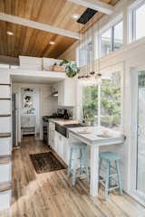 Corresponding with the exterior facade, cedar runs along the ceiling and interior walls. The back half of the home features a galley-style kitchen with full-size sink, stove, and fridge.