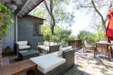 Outside, a partially covered patio provides a shady perch above the gently sloping backyard.