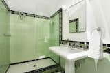 The second-floor bathroom has brightly colored tiles and a large, walk-in shower.