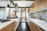 The galley-style kitchen was updated by interior designer Thomas Michna in 2008. A floor-to-ceiling window illuminates the space from one end.