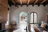 A pair of arched glass doors open to the courtyard, which fills the outdoor space between two wings of the home.