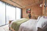 The sunlit bedroom looks out onto skyline views of London.  Photo 8 of 11 in A Penthouse Apartment in a London Water Tank Offers Utilitarian Style for $781K