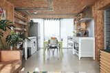 An open kitchen and living area occupy the lower level. The kitchen is organized using several stand-alone metal units, along with open shelving on both sides.  Photo 3 of 11 in A Penthouse Apartment in a London Water Tank Offers Utilitarian Style for $781K