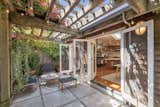 Outside, a pair of French doors connect the kitchen/dining area with a pergola-topped patio.  Photo 11 of 13 in An Idyllic Cottage With a Garden Studio Seeks $1.8M in San Francisco