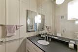 The bathroom features a custom vanity and glass shower, as well as Hansgrohe faucets.