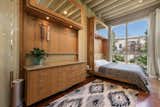 Located along the front of the home and accessible from the living area, the bedroom features a 16-foot-tall window at one end. A built-in bamboo dresser complements the custom bed.&nbsp;&nbsp;