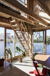Homeowners Wouter Valkenier and Mijke de Kok, both architects, cobbled together salvaged material from multiple sources to fit out their home. Wooden beams in the dining room, normally a double-height open space, can be covered over as needed to create an extra living area above—without disrupting views of the water.