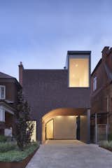 Exterior, Brick Siding Material, and House Building Type The arc of Erminia and Enzo Mancuso’s integrated carport acts as a portico and plays off the home’s roofline, which steps up to meet the height of neighboring houses.  Photo 2 of 7 in A Toronto Residence Reinterprets the City’s History With a Standout Facade