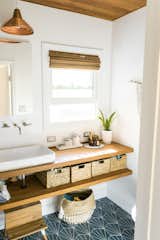 The updated bathroom offers a custom vanity and copper light fixture.