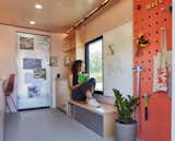 Workshop tools hang from a pegboard, and built-in storage that doubles as seating makes for a comfortable and inviting space for students.