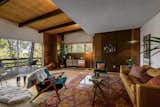 Inside the front entryway, a living area fills one side of the upper level. Original beamed and wood-clad ceilings mix with original wood paneling and vintage light fixtures.  Photo 2 of 15 in This $1.2M California Midcentury House Looks Like It Came Straight Out of “Mad Men”