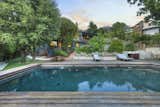 Another view of the pool area shows a small lawn along one side. A terraced area between the pool and house contains several fruit trees.  Photo 23 of 24 in Asking $3.75M, This Bohemian Hillside Home in L.A. Comes Complete With a Potter’s Studio