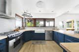 Opposite from the dining area the brightly lit kitchen features colored cabinetry and wood countertops.  Photo 6 of 24 in Asking $3.75M, This Bohemian Hillside Home in L.A. Comes Complete With a Potter’s Studio