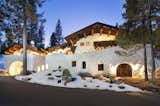 The facade is illuminated at night by numerous lights along the exterior.  Photo 15 of 15 in Listed for $2.65M, This Bavarian-Style “Snow Haus” Near Lake Tahoe Is the Perfect Alpine Escape