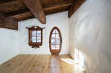 All of the home's seven bedrooms feature intricate window trim and other wood details. Here, one bedroom comes with a whimsically shaped door that provides direct access to the exterior.  Photo 6 of 15 in Listed for $2.65M, This Bavarian-Style “Snow Haus” Near Lake Tahoe Is the Perfect Alpine Escape