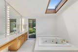 The adjoining bathroom comes with a floor-to-ceiling window and skylight.&nbsp;