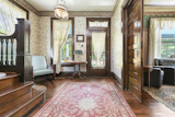 A look at the foyer today reveals similar wallpaper as that shown in the film. The layout features a formal sitting room to one side, separated by large pocket doors.