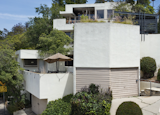 An exterior view shows the corner of the building, which sits on a triangular-shaped lot along Carnation Avenue and Lucile Avenue in Silver Lake. The cantilevered pergola designed by architect William Krisel in 1949 is still standing along one of the unit's terraces.  Photo 1 of 14 in A Newly Restored Schindler Building Lists for $3.65M in L.A.