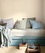 Muslin provides a muted backdrop for a daybed dressed in blues and greens.
