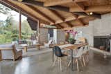 Supporting the dramatic roofline is a central iron beam that runs diagonally across the ceiling. Near the kitchen, a stained glass window hangs over the doorway.