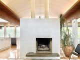 The updated fireplace, now painted white, retains the original floating hearth.