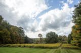 The patio also overlooks a large lawn, as well as the property's lush fields and woodland.  Photo 14 of 14 in For $795K, This 1865 Greek Revival Farmhouse Could Be Your Escape From New York
